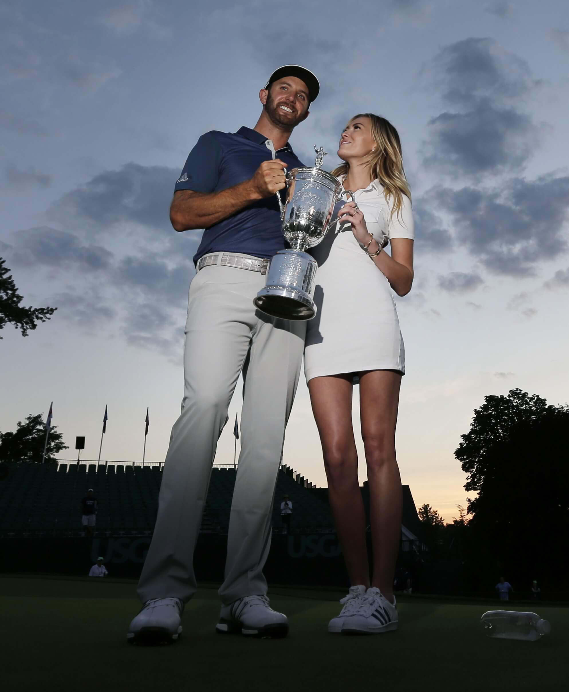 Image of Dustin Johnson with his fiancee and his US Open trophy.